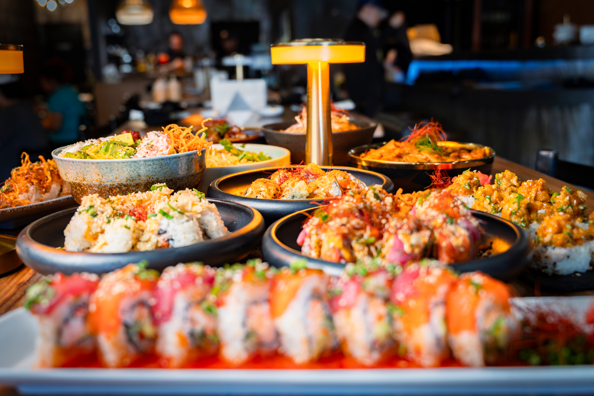 Mesa BYKO repleta de rollos de sushi y poke